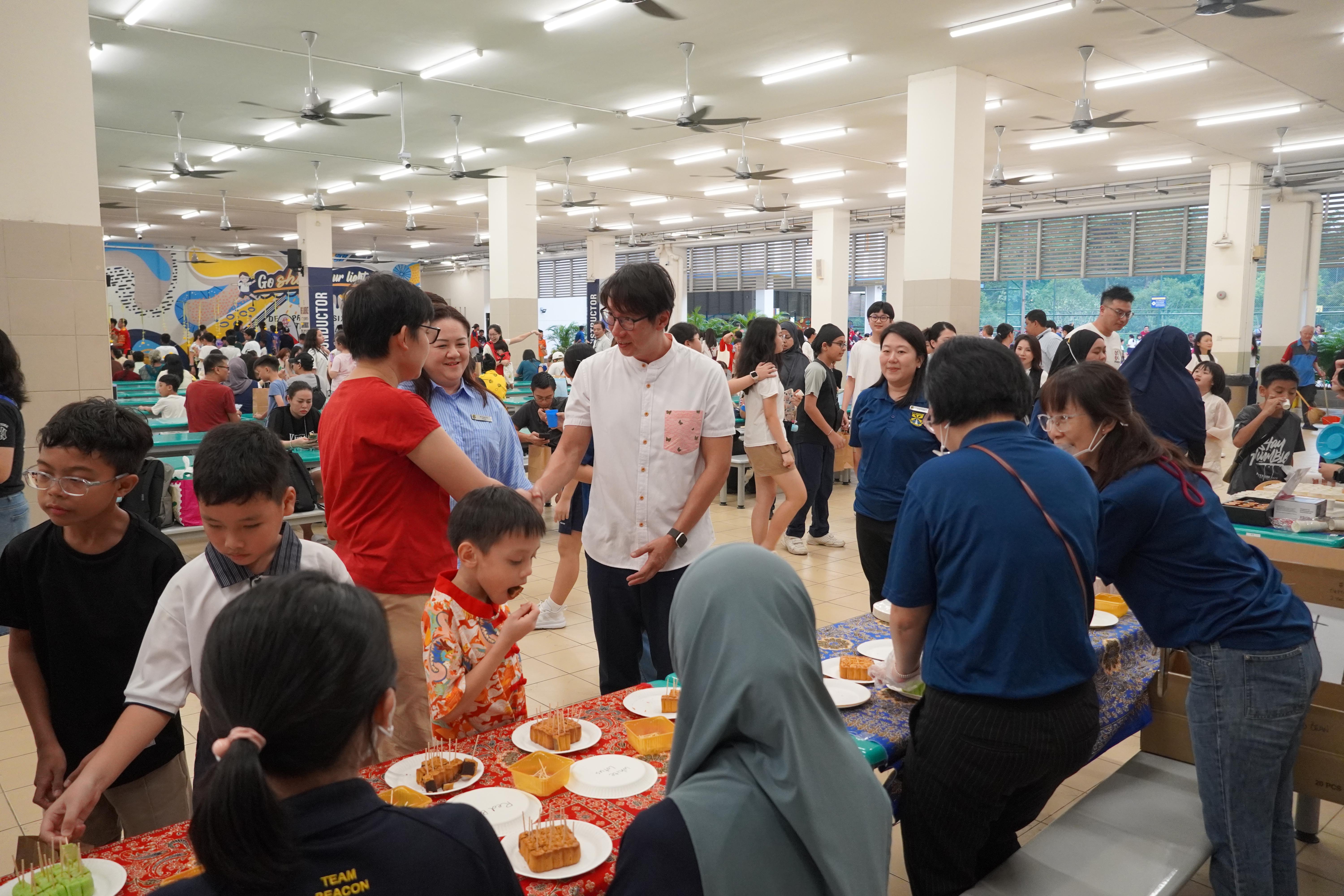 Mr Edward Chia mingles with families and students as they enjoy the cultural activities together.
